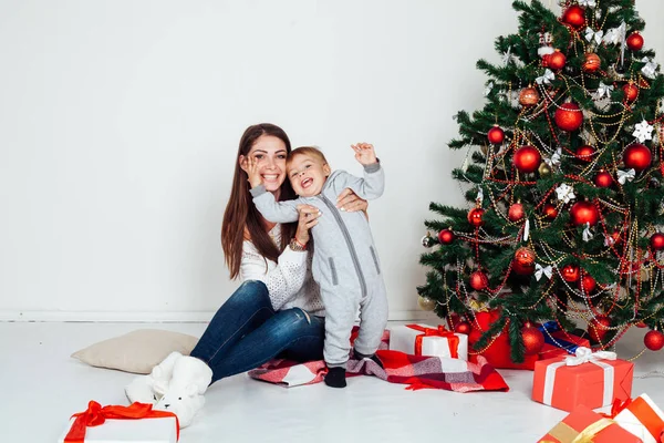 Mamma och pojke på julgran med gåvor 1 — Stockfoto