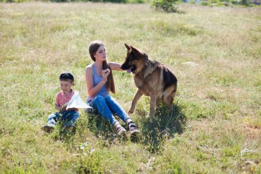 Alman çoban köpeğiyle yürüyüşe çıkmış bir kadın.