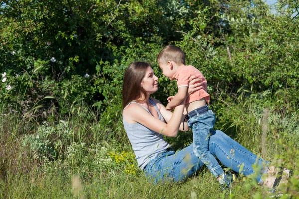 Hermosa mamá con su hijo en un descanso de picnic en la naturaleza — Foto de Stock