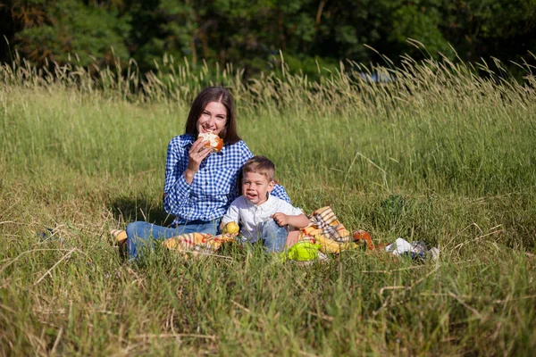 Belle maman avec son fils sur un pique-nique repos dans la nature — Photo