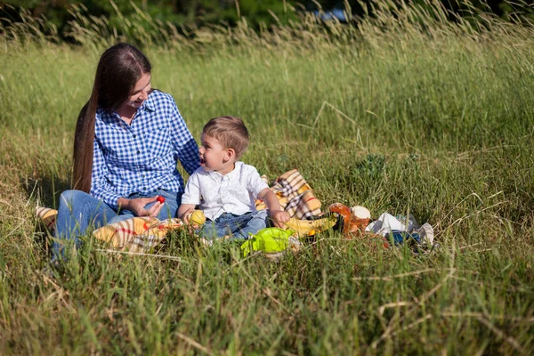 Schöne Mutter mit ihrem Sohn bei einem Picknick in der Natur — Stockfoto