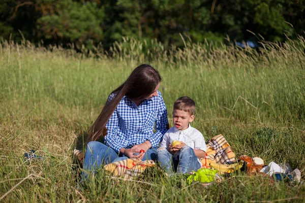 Piękna mama z synem na pikniku w przyrodzie — Zdjęcie stockowe