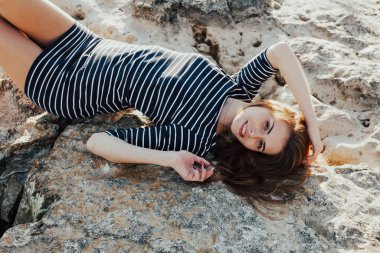 Kız bir taş Beach Sırtüstü yatıyor