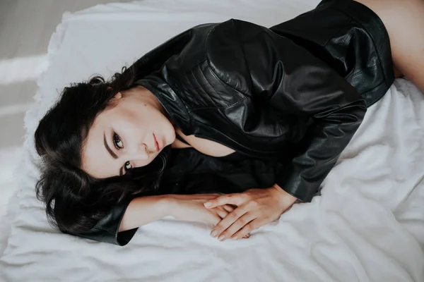 Дівчина в чорній білизні лежить на білому ліжку — стокове фото