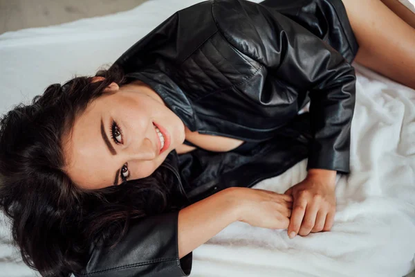 Girl in black lingerie is lying on a white bed — Stock Photo, Image