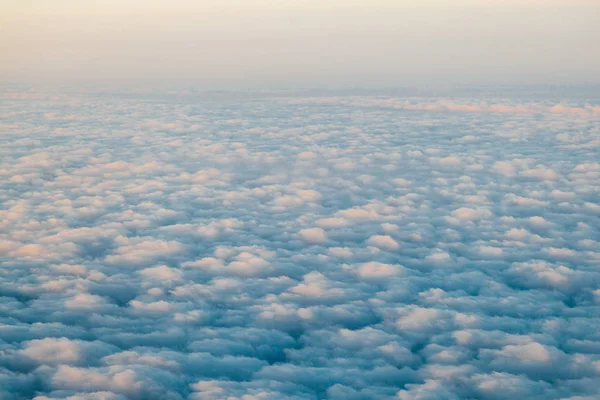 Volant au-dessus des nuages au coucher du soleil depuis un avion — Photo