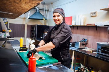 Aşçı kadın suşi restoranının mutfağını hazırlıyor.