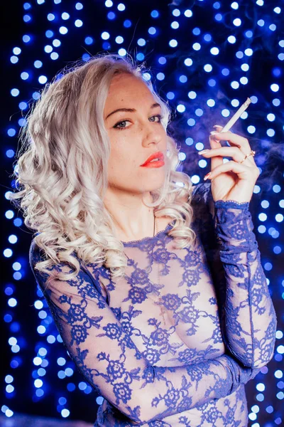 seksi sarışın mavi lingerie kırmızı dudaklar sigara içiyor