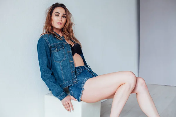 Retrato de uma bela mulher na moda em jeans e estilo lingerie preta — Fotografia de Stock