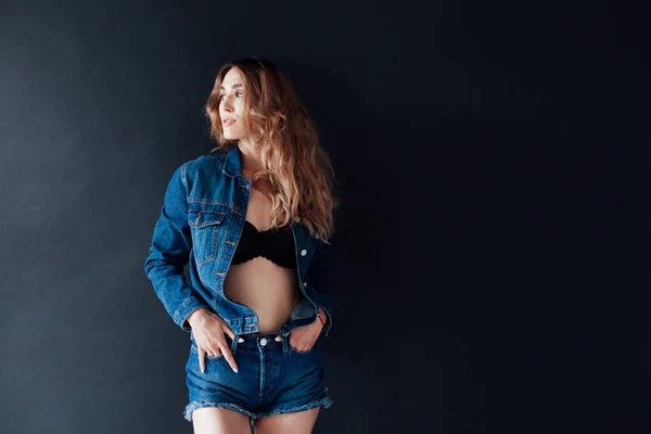 Ritratto di una bella donna alla moda in jeans e lingerie nera — Foto Stock