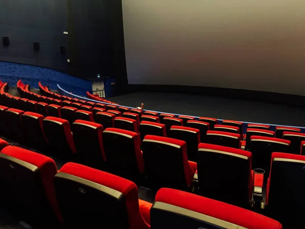 Sièges vides dans un cinéma à grand écran sans personnel — Photo