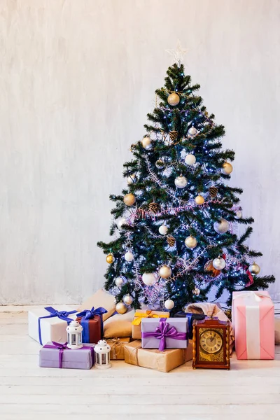 Árbol de Navidad con luces guirnaldas adornadas con regalos de año nuevo —  Fotos de Stock