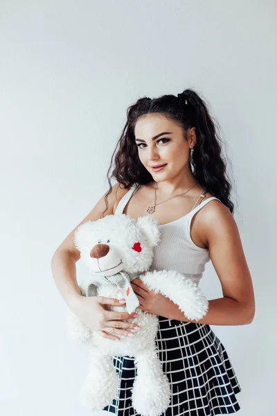 Ritratto di una bella donna bruna alla moda con un orso polare morbido giocattolo — Foto Stock