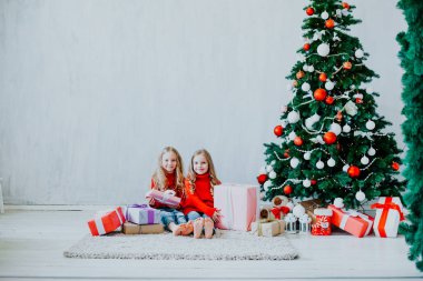 iki küçük kız sarışın Noel hediyeleri yeni yıl tatili, kırmızı elbiseli