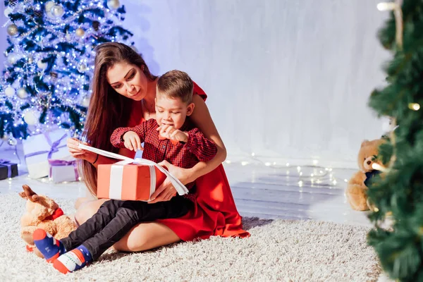 Mãe e menino abrem presentes árvore de Natal ano novo — Fotografia de Stock