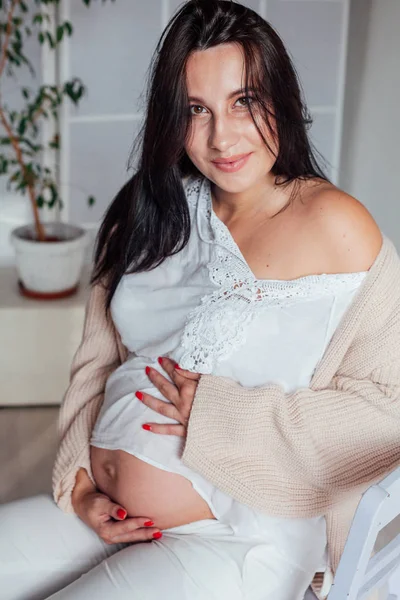 Hermosa mujer embarazada en una habitación blanca —  Fotos de Stock