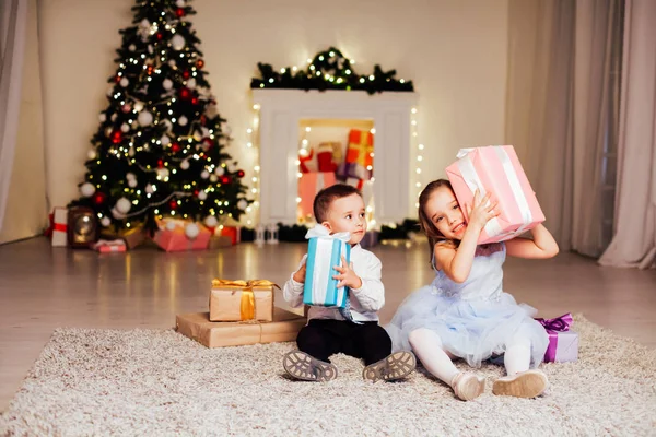 Mały chłopiec i dziewczynka otworzyć Boże Narodzenie prezenty nowego roku zima Christmas tree — Zdjęcie stockowe