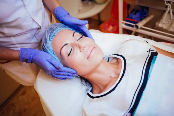 Medico cosmetologo facendo massaggio facciale ragazza Spa — Foto Stock