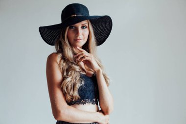 Sarışın, mavi gözlü, beyaz arkaplan kenarlı bir şapka.