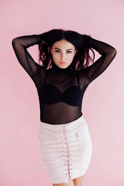 Retrato de una chica en un vestido negro sobre un fondo rosa — Foto de Stock