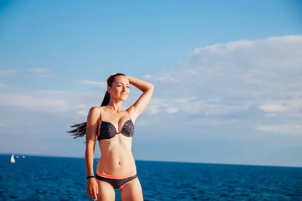 Girl in bathing suit sunning on the beach sea — Stock Photo, Image