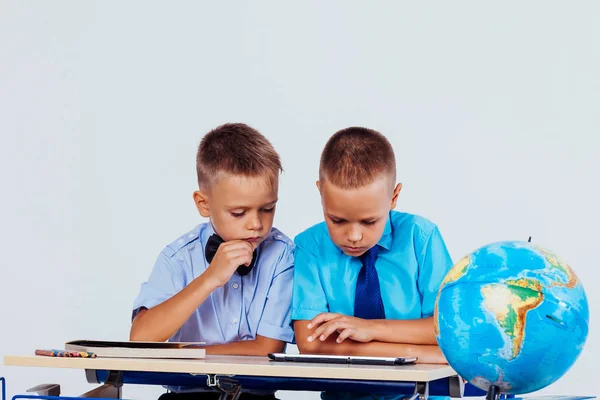 二人の少年は、インター ネット タブレット学校を見ています。 — ストック写真