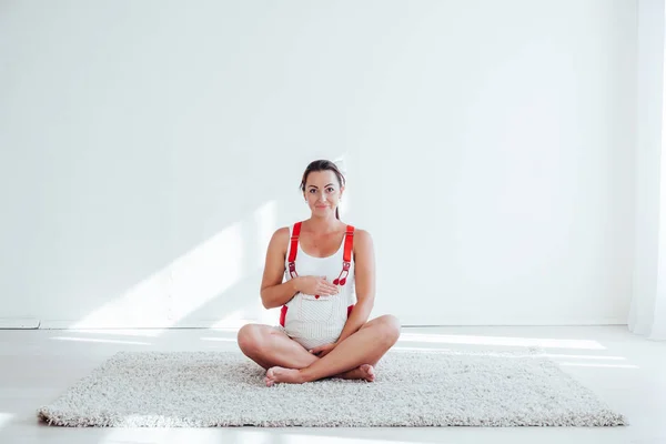 Een zwangere vrouw houdt zich bezig met gymnastiek en yoga — Stockfoto