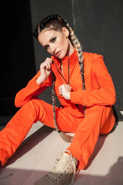 Retrato de uma bela mulher na moda com tranças em roupas laranja — Fotografia de Stock