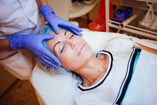 Medico cosmetologo facendo massaggio facciale ragazza Spa — Foto Stock