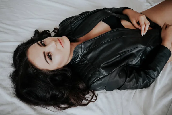 Chica en ropa interior negro está acostado en una cama blanca — Foto de Stock
