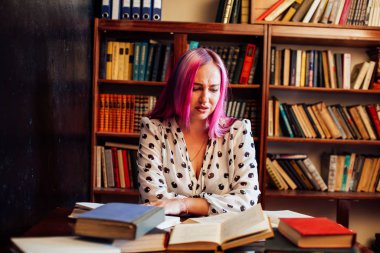 pembe saçlı güzel kadın kitap kütüphanesi okur