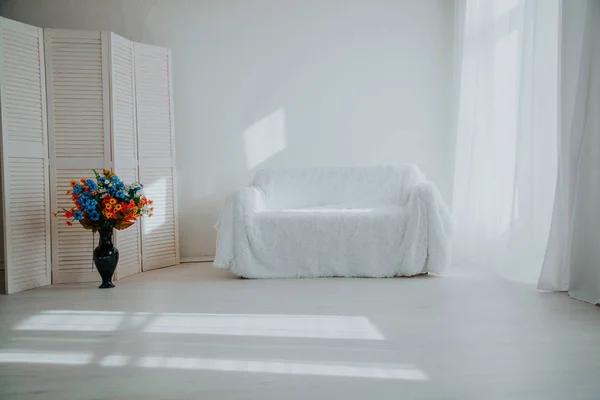 Arredamento casa camera bianca con divano e fiori in un vaso — Foto Stock