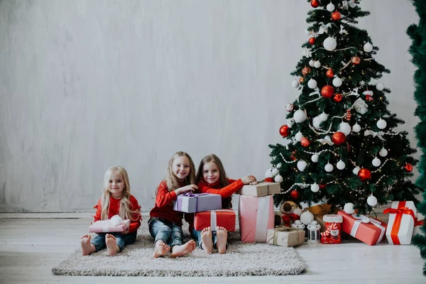 Three girls blonde sisters girlfriends gift new year tree holiday Christmas — Stock Photo, Image