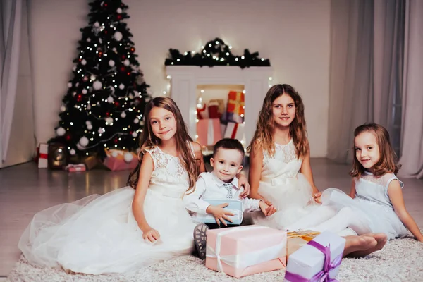 Niños abren regalos de Navidad año nuevo luces de vacaciones chispas — Foto de Stock