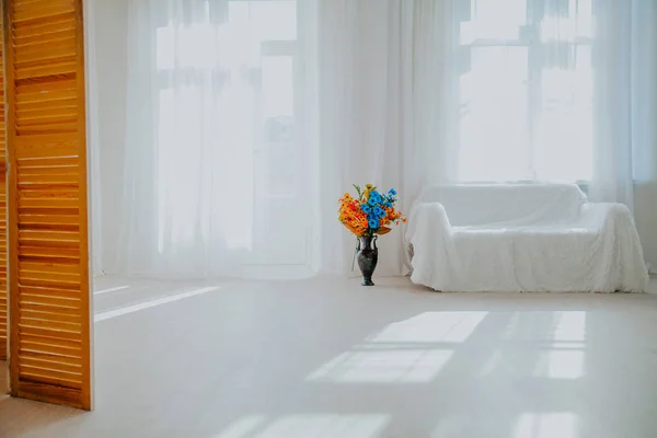 Casa decoração quarto branco com sofá e flores em um vaso — Fotografia de Stock