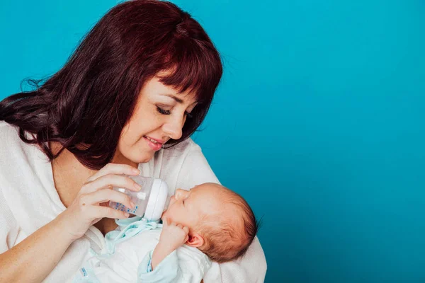 A mãe está alimentando o leite do bebê de uma mamadeira — Fotografia de Stock