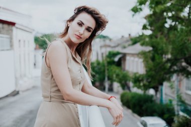 Bej renkli açık renk elbisesi olan güzel ve şık bir kadının portresi.