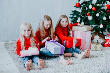 Üç küçük kızlar sarışın Noel hediyeleri Noel ağacı Yılbaşı açın