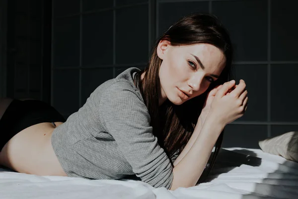 Hermosa mujer en ropa interior se encuentra en la cama en el dormitorio —  Fotos de Stock