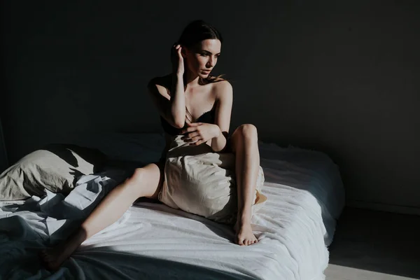 Belle femme en sous-vêtements dans la chambre sur le lit le matin — Photo