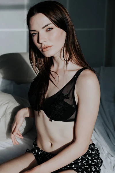 Femme en sous-vêtements se trouve sur le lit dans la chambre le matin — Photo