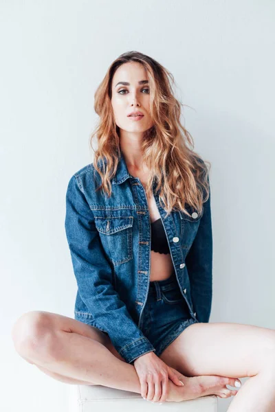 Portrait of a beautiful fashionable woman in a denim jacket and shorts — Stock Photo, Image