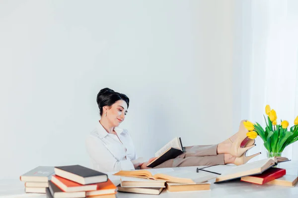 Una mujer en un traje de negocios lee libros en la Oficina — Foto de Stock