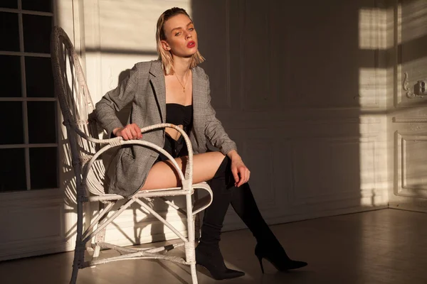Retrato de una hermosa mujer rubia de moda en una silla elegante —  Fotos de Stock