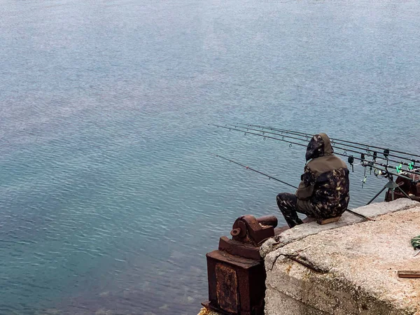 Man catches fish out of water on fishing rods