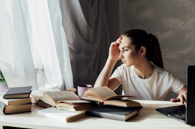 Güzel kız sınava hazırlanıyor ve bir kitap okuyor.