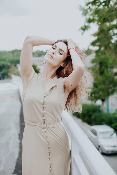 Retrato de una hermosa mujer de moda en un vestido gris en un paseo —  Fotos de Stock