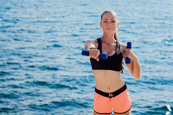 Bonita chica haciendo ejercicios de fitness con mancuernas — Foto de Stock