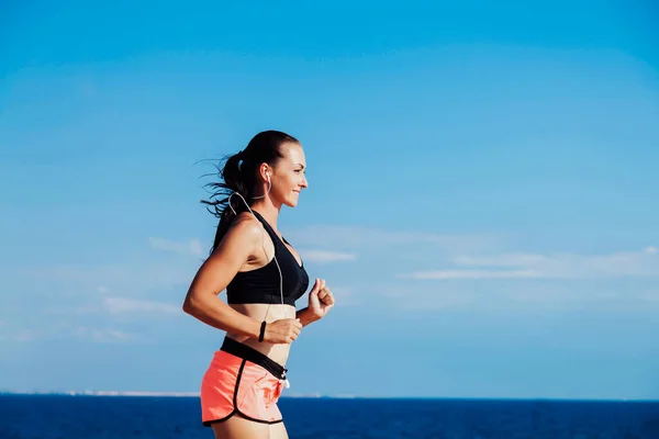 Girl goes in for sports runs and listen to music — стоковое фото