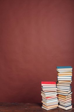 Kahverengi arka plan üzerine enstitüde sınavlara hazırlanmayı öğrenmek için birçok eğitim kitabı yığını